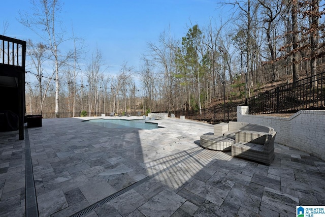 view of swimming pool with a patio area, fence, and a fenced in pool