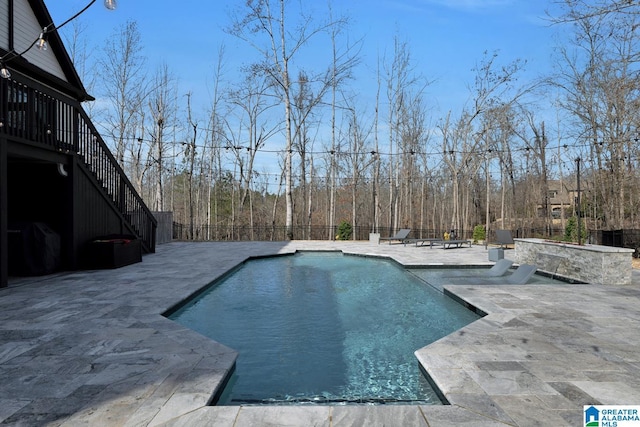 view of pool featuring a fenced in pool, a patio, stairway, and fence