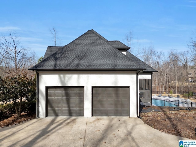 view of property exterior featuring a garage, fence, and roof with shingles