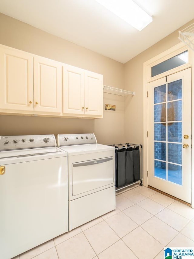 laundry area with cabinet space, light tile patterned floors, and washing machine and clothes dryer