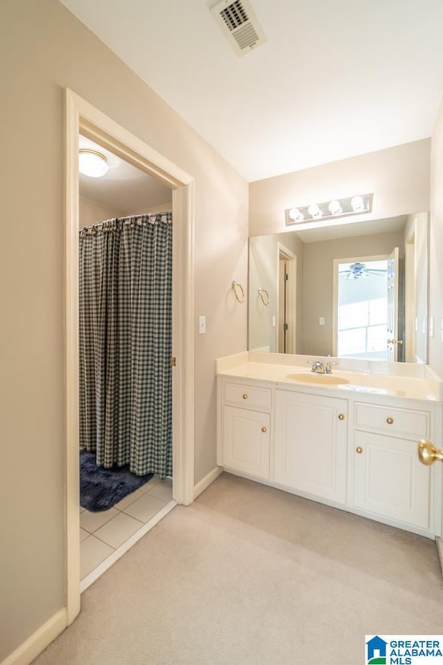 full bath with a shower with shower curtain, baseboards, visible vents, and vanity