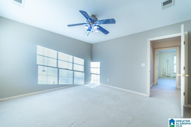 spare room featuring light carpet, baseboards, visible vents, and ceiling fan