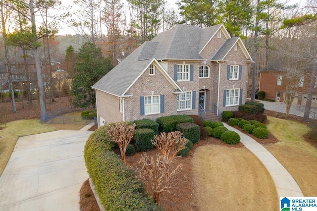 view of front of property featuring brick siding and a shingled roof