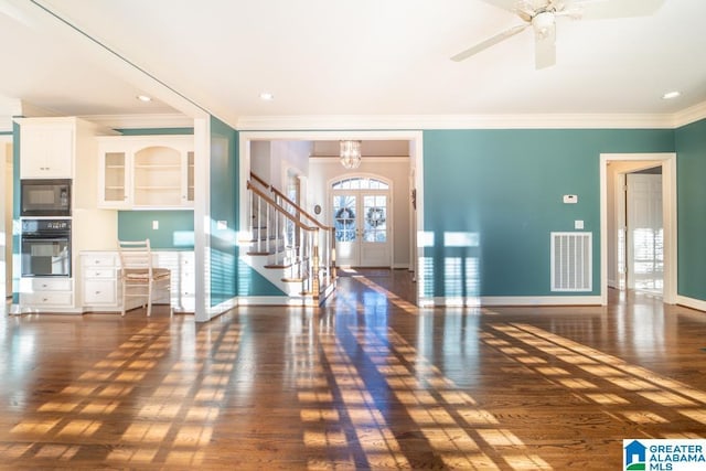 entryway with ornamental molding, wood finished floors, visible vents, and baseboards