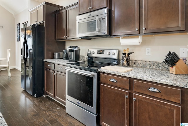 kitchen featuring light stone counters, dark wood-style flooring, dark brown cabinets, appliances with stainless steel finishes, and crown molding