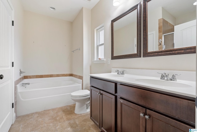 full bathroom with a sink, a garden tub, double vanity, and toilet