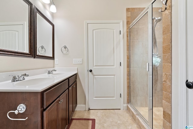 full bath featuring a shower stall, double vanity, tile patterned floors, and a sink