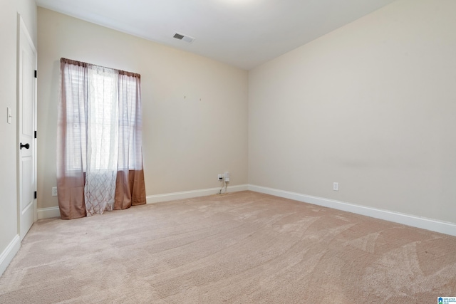 carpeted spare room with visible vents and baseboards