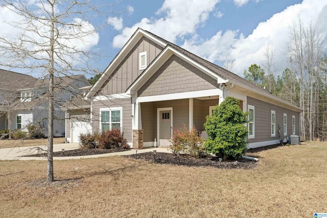 craftsman house featuring central AC unit, board and batten siding, driveway, and a front yard