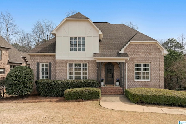 view of front of property featuring brick siding and a shingled roof