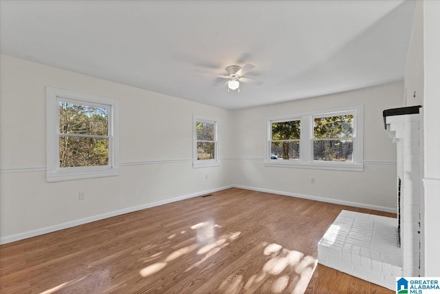 empty room featuring plenty of natural light, baseboards, and wood finished floors