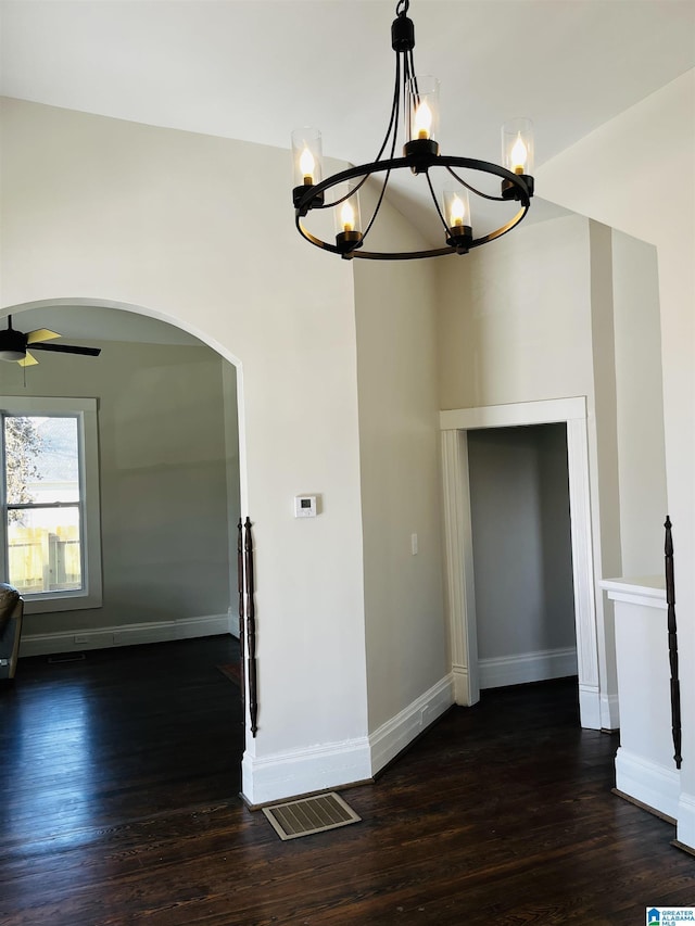 interior space with ceiling fan with notable chandelier, baseboards, and dark wood-style flooring