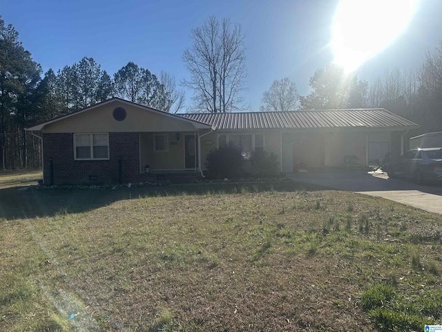 ranch-style house featuring metal roof, brick siding, concrete driveway, crawl space, and a front lawn