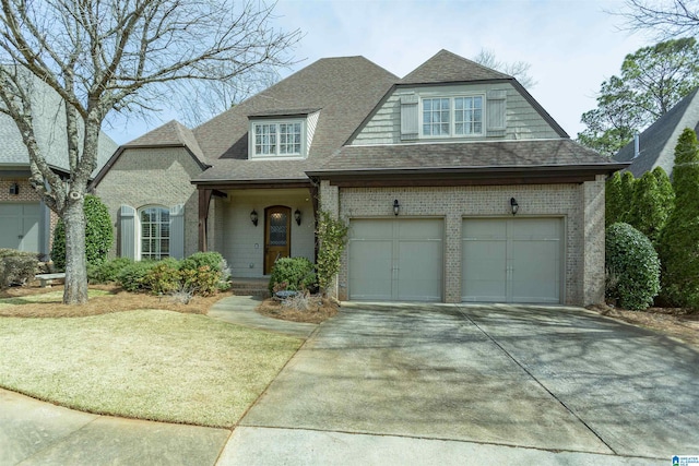 view of front facade with a garage, concrete driveway, brick siding, and roof with shingles