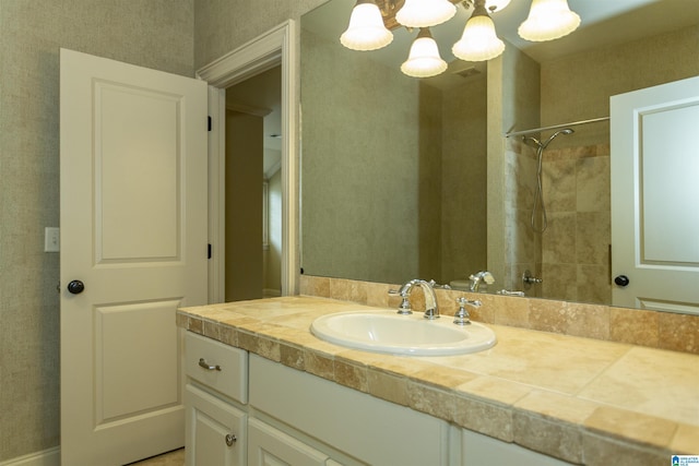 bathroom featuring tiled shower and vanity