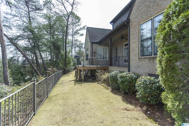 view of yard featuring ceiling fan and fence