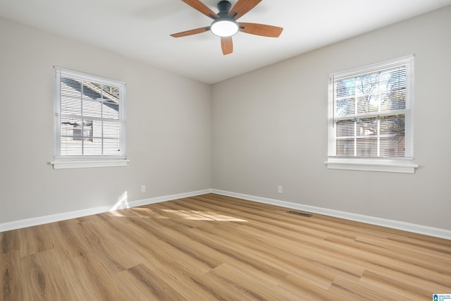 empty room with light wood finished floors, visible vents, baseboards, and a ceiling fan