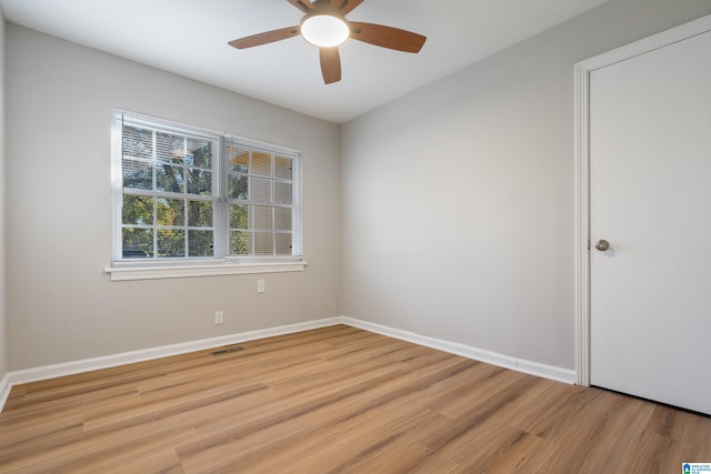 spare room with light wood-style flooring, visible vents, baseboards, and ceiling fan