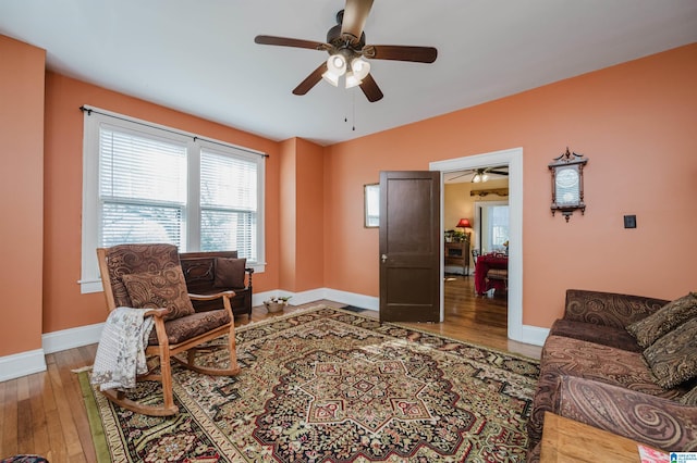 interior space with ceiling fan, wood finished floors, and baseboards