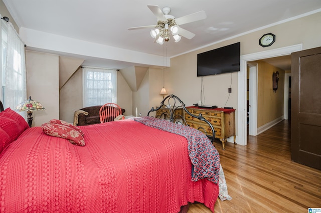 bedroom featuring crown molding, a ceiling fan, and wood finished floors