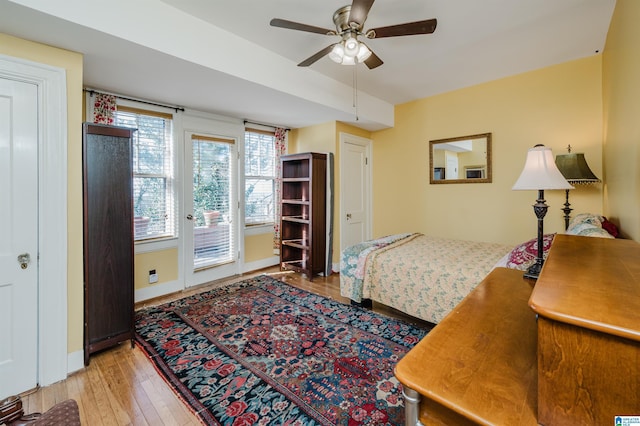 bedroom featuring access to outside, hardwood / wood-style floors, a ceiling fan, and baseboards