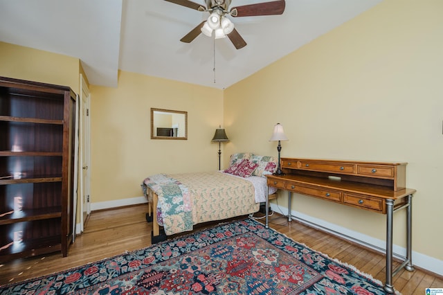 bedroom with ceiling fan, hardwood / wood-style flooring, and baseboards