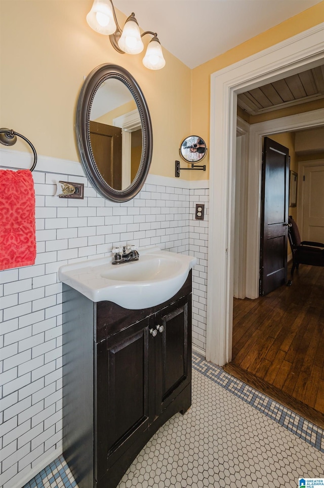 bathroom featuring a wainscoted wall, tile walls, and vanity