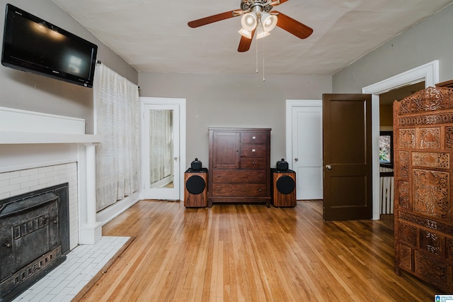 living room with hardwood / wood-style floors, a fireplace, and a ceiling fan