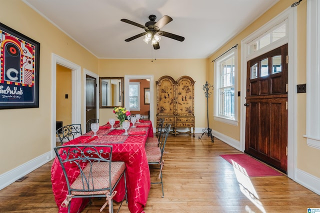 dining room featuring ceiling fan, hardwood / wood-style floors, and baseboards