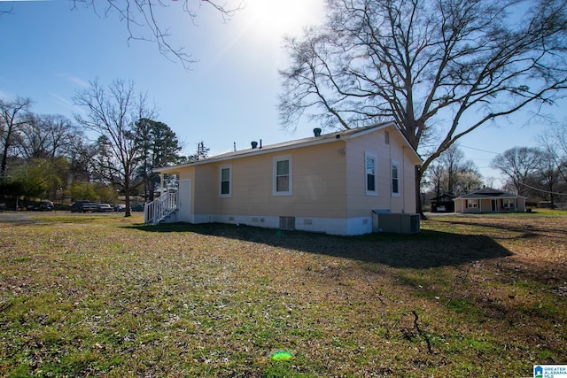 view of property exterior with crawl space, a lawn, and central AC unit