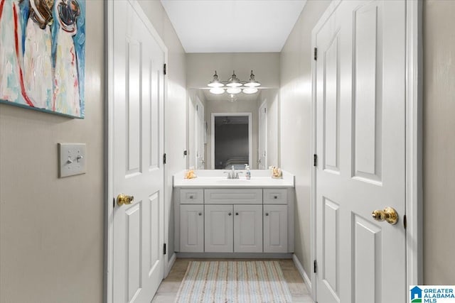 bathroom with ensuite bath, wood finished floors, and vanity