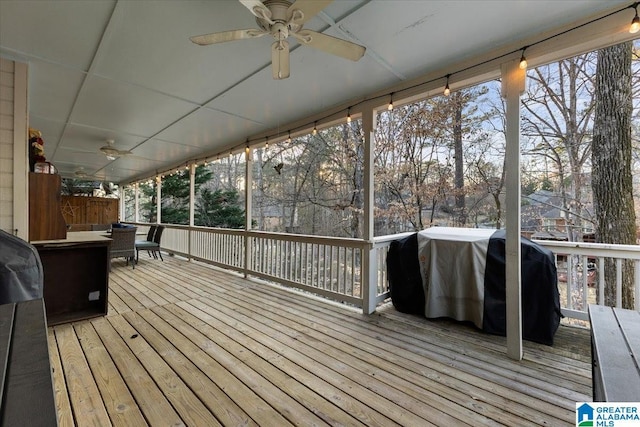 wooden terrace with grilling area and a ceiling fan