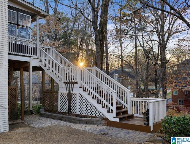 exterior space with brick siding, stairs, and a wooden deck