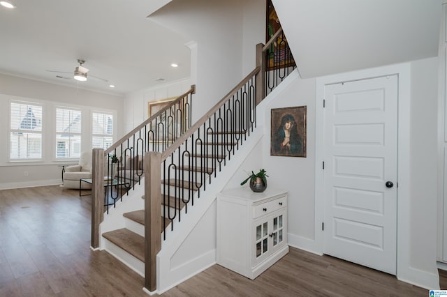 staircase with baseboards, ornamental molding, and wood finished floors