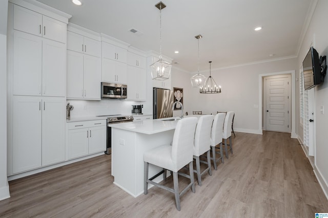 kitchen featuring a kitchen island with sink, visible vents, stainless steel appliances, and crown molding