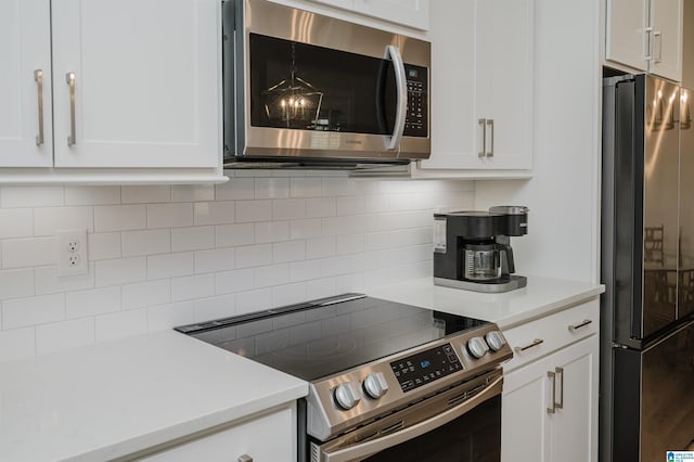 kitchen with appliances with stainless steel finishes, light countertops, white cabinetry, and backsplash