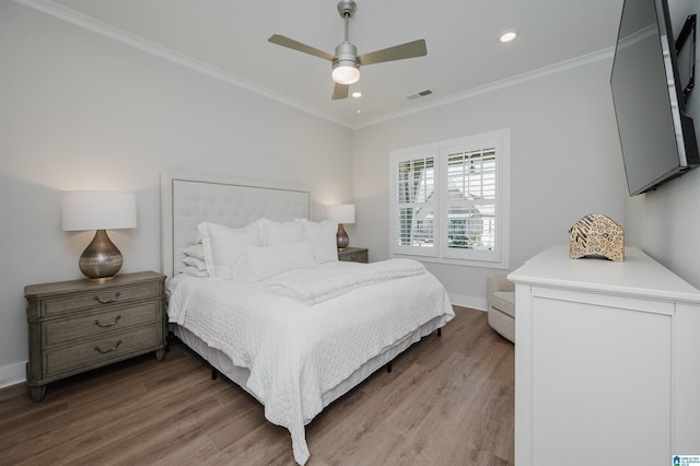 bedroom featuring light wood-style flooring, recessed lighting, visible vents, baseboards, and crown molding