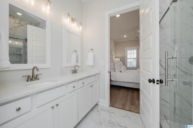 ensuite bathroom with marble finish floor, connected bathroom, a marble finish shower, and a sink