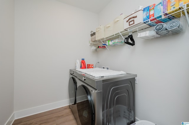 washroom with laundry area, independent washer and dryer, baseboards, and wood finished floors