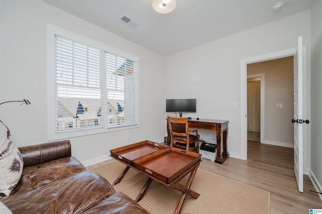 living area featuring light wood-type flooring, baseboards, and visible vents