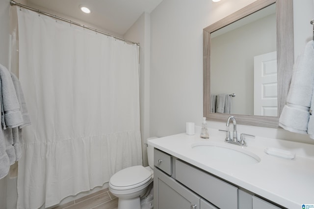 full bath featuring toilet, a shower with shower curtain, wood finished floors, and vanity