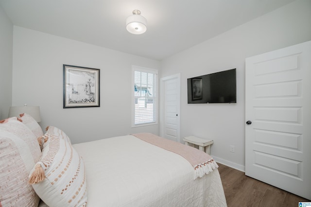 bedroom with baseboards and dark wood-style flooring