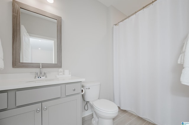 bathroom with a shower with shower curtain, vanity, and toilet