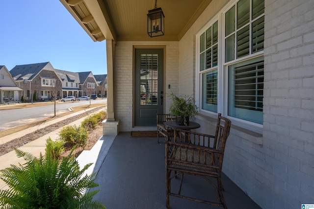 property entrance with a porch, a residential view, and brick siding