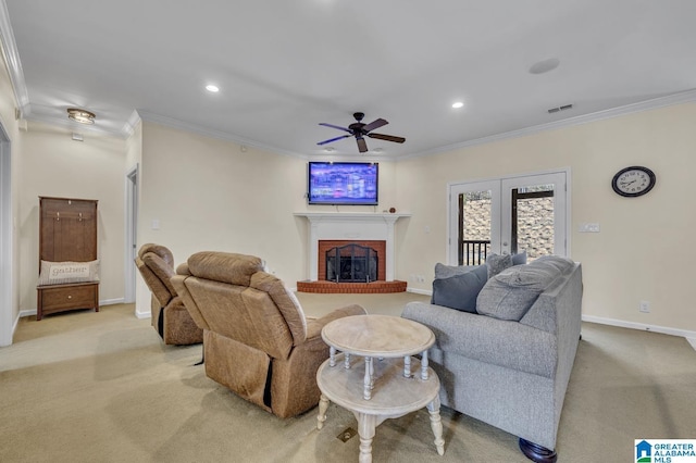 carpeted living area featuring visible vents, baseboards, ceiling fan, ornamental molding, and a fireplace