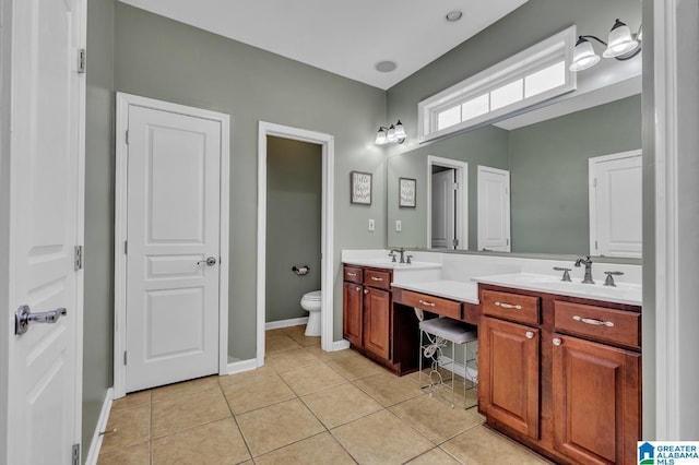 full bathroom with tile patterned flooring, double vanity, toilet, and a sink