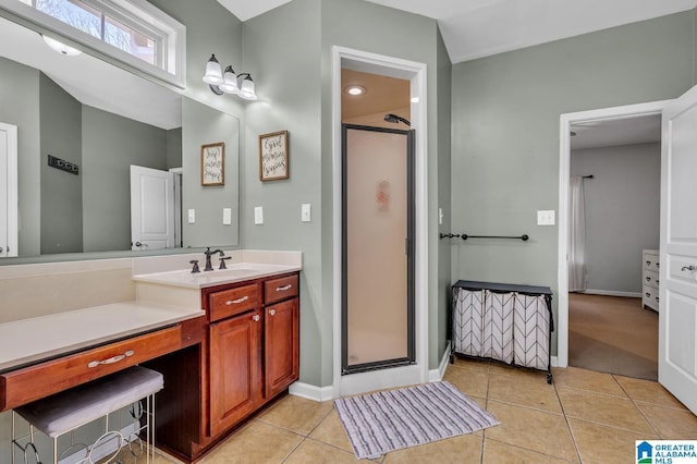 full bathroom featuring tile patterned floors, baseboards, vanity, and a shower stall