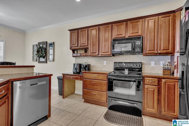 kitchen with black appliances, crown molding, light tile patterned floors, decorative backsplash, and tile counters