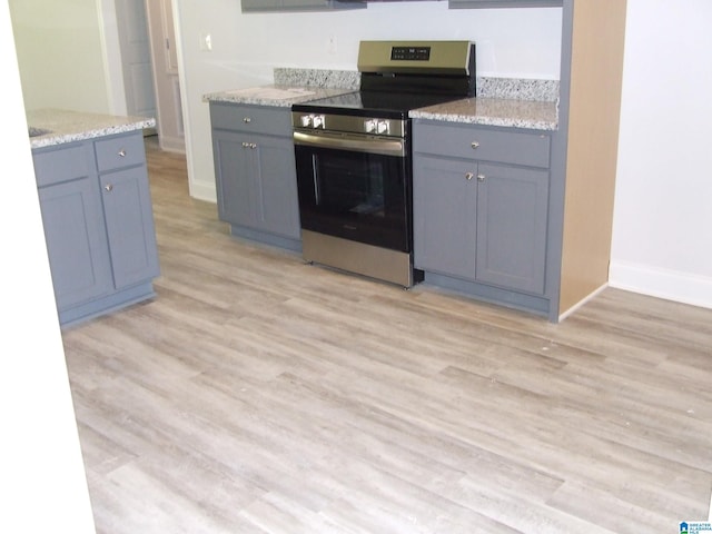 kitchen with electric range, gray cabinets, light wood-style flooring, and baseboards