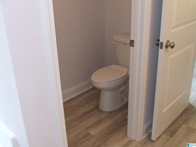 bathroom featuring wood finished floors, toilet, and baseboards